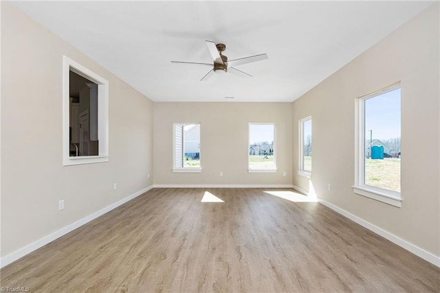 empty room featuring wood finished floors, baseboards, and a ceiling fan