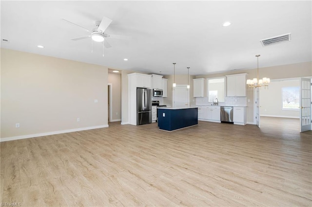 kitchen with visible vents, a center island, appliances with stainless steel finishes, open floor plan, and light wood finished floors