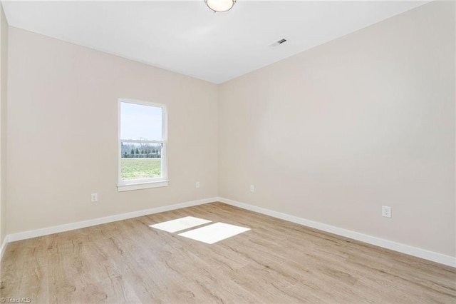 spare room with light wood-style floors and baseboards