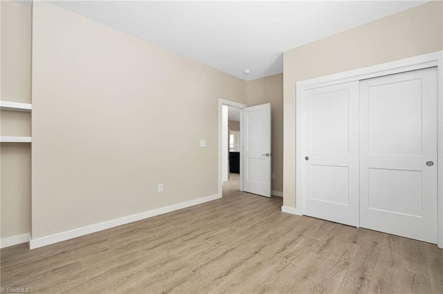 unfurnished bedroom featuring a closet, baseboards, and wood finished floors