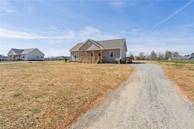 craftsman house with a front yard, a porch, and driveway