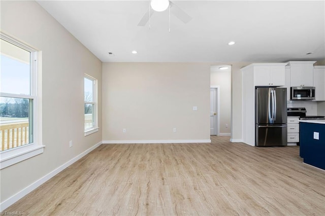 kitchen with baseboards, ceiling fan, white cabinetry, light wood finished floors, and stainless steel appliances