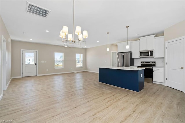 kitchen featuring visible vents, appliances with stainless steel finishes, a kitchen island, and plenty of natural light