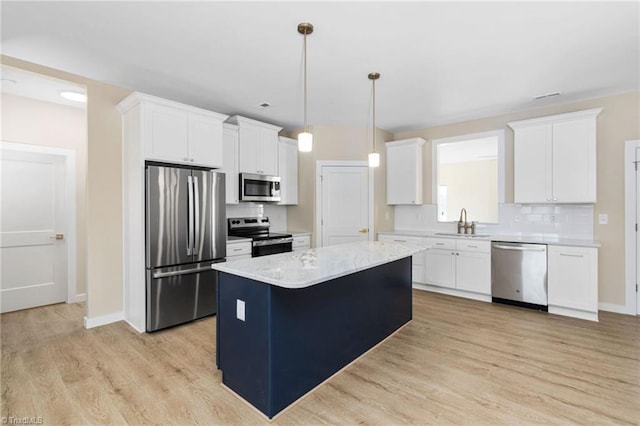 kitchen featuring light wood-type flooring, a center island, a sink, and appliances with stainless steel finishes