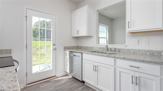 kitchen with sink, white cabinetry, light stone counters, light hardwood / wood-style flooring, and stainless steel dishwasher