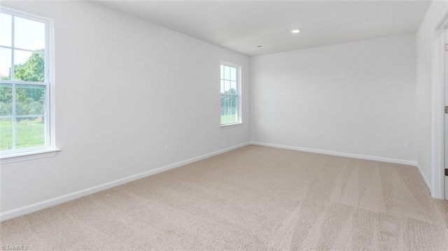 carpeted spare room featuring a healthy amount of sunlight