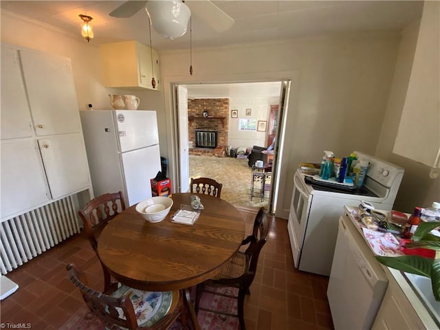 dining area featuring a brick fireplace, washer / clothes dryer, and ceiling fan