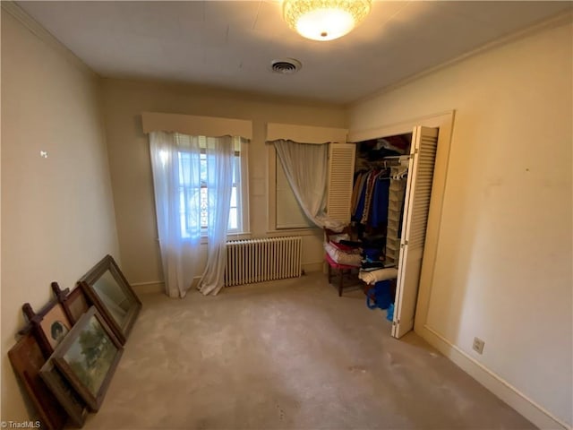 unfurnished bedroom featuring carpet, radiator, and a closet