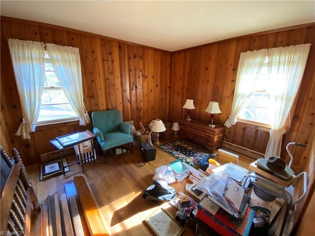 sitting room featuring a baseboard radiator, hardwood / wood-style floors, and wood walls