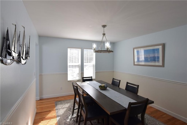 dining area with a chandelier and light hardwood / wood-style flooring