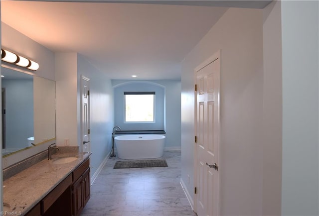 bathroom with vanity and a bath