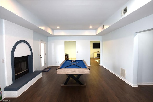 rec room featuring a raised ceiling, dark hardwood / wood-style floors, a fireplace, and billiards