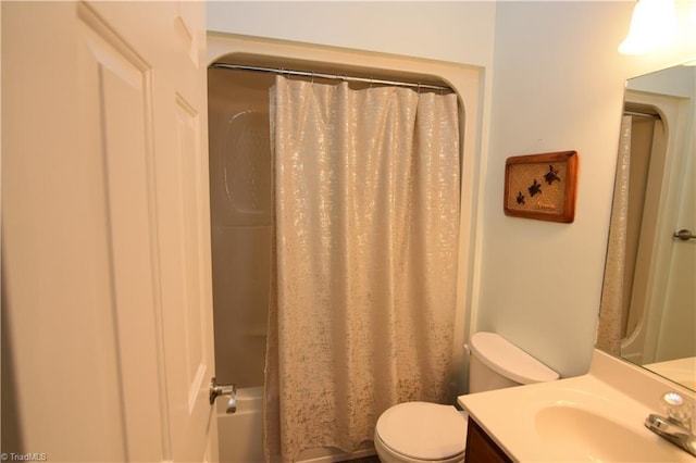 bathroom featuring toilet, vanity, and a shower with shower curtain