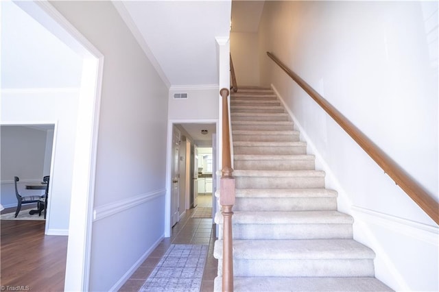 staircase featuring ornamental molding and hardwood / wood-style floors