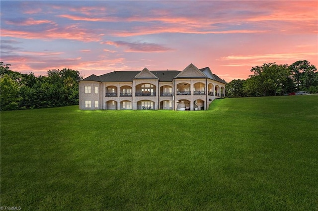 view of front of home featuring a balcony and a lawn