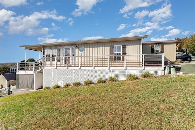 back of house featuring a wooden deck and a yard