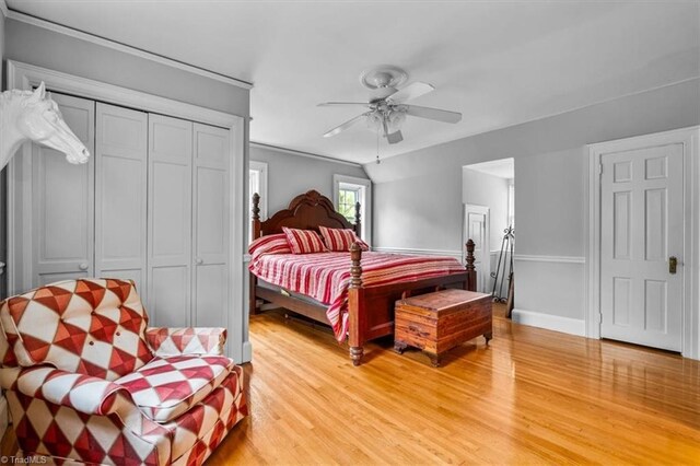 bedroom featuring light wood finished floors, a ceiling fan, baseboards, and crown molding