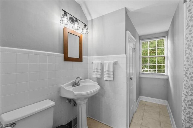 full bath with toilet, a wainscoted wall, and tile patterned floors