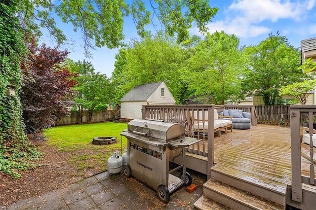 deck with area for grilling, an outbuilding, and an outdoor living space with a fire pit