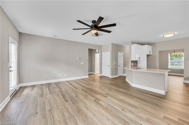 1333 Union Cross Rd, Kernersville, NC 27284 - unfurnished living room featuring light wood finished floors, baseboards, a ceiling fan, and a chandelier
