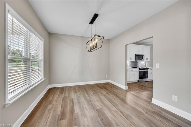 1333 Union Cross Rd, Kernersville, NC 27284 - unfurnished dining area with light wood-style flooring, baseboards, and a chandelier