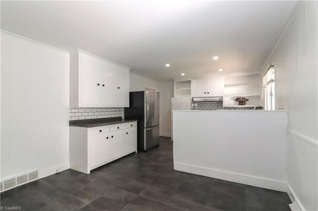 kitchen featuring ornamental molding, stainless steel fridge, decorative backsplash, and white cabinetry