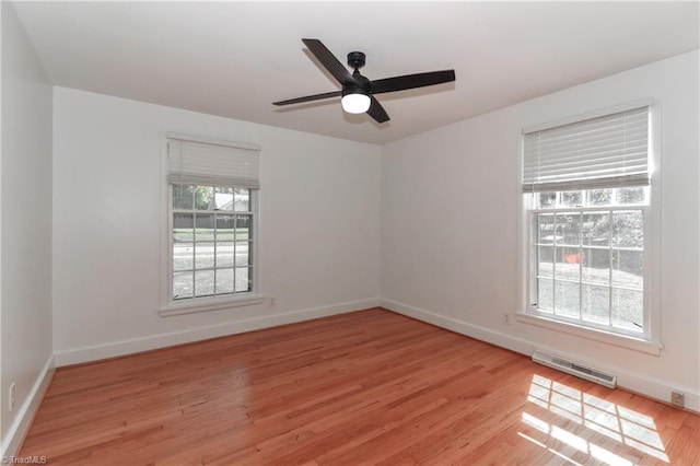 spare room featuring light wood-type flooring, ceiling fan, and a healthy amount of sunlight