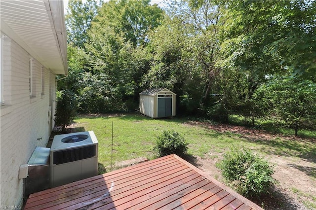 wooden terrace with a storage shed and a yard