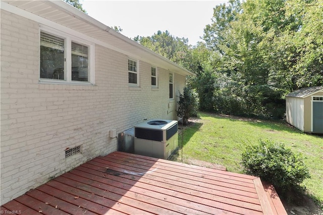 wooden deck featuring a yard, central AC unit, and a storage shed