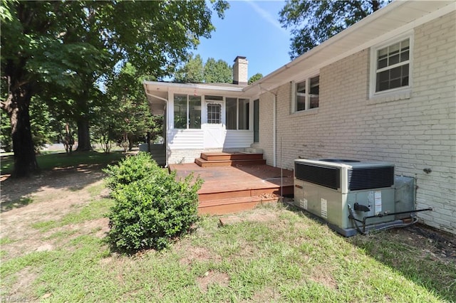 rear view of property with a deck and cooling unit