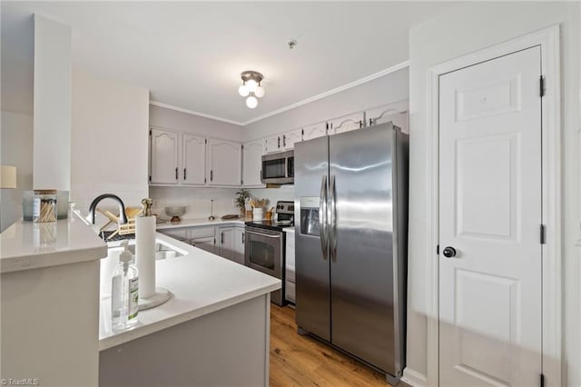 221 Quietwood Dr Unit 221, Winston-Salem, NC 27103 - kitchen with stainless steel appliances, light countertops, a peninsula, light wood-style flooring, and ornamental molding