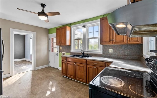 kitchen with black range with electric cooktop, a sink, ventilation hood, brown cabinets, and decorative backsplash