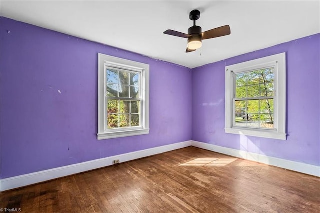 spare room featuring ceiling fan, wood-type flooring, and baseboards