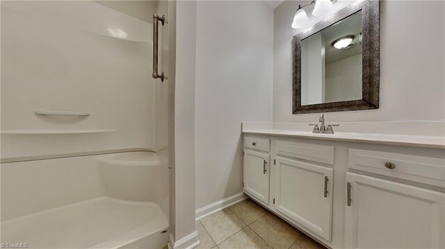 full bathroom featuring baseboards, a shower, tile patterned flooring, and vanity