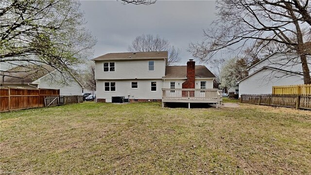 rear view of house with a chimney, a wooden deck, a fenced backyard, central AC unit, and a lawn