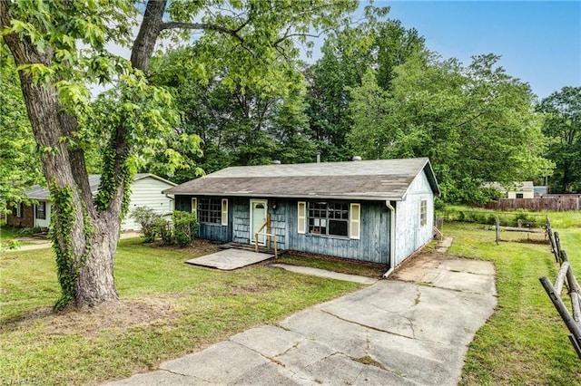 bungalow-style home featuring fence, a shingled roof, concrete driveway, a front yard, and a porch