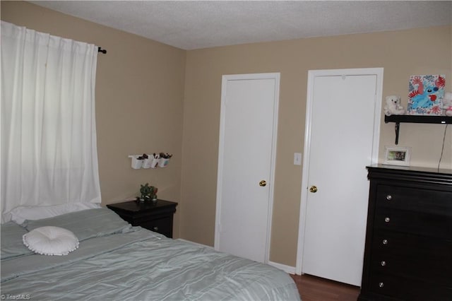 bedroom with a textured ceiling and wood finished floors