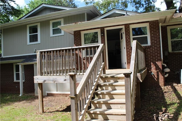 rear view of property with a deck and brick siding