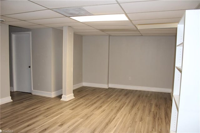 finished basement with a drop ceiling, baseboards, and wood finished floors