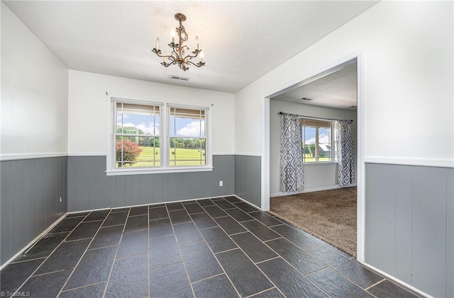306 Pratt Rd, Dobson, NC 27017 - spare room with wainscoting, a chandelier, and a textured ceiling
