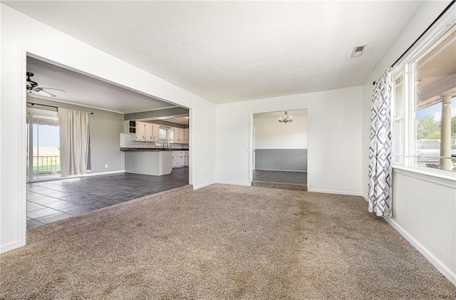 306 Pratt Rd, Dobson, NC 27017 - unfurnished living room featuring carpet floors, healthy amount of natural light, a chandelier, and a ceiling fan