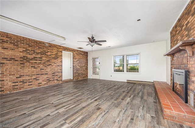 306 Pratt Rd, Dobson, NC 27017 - unfurnished living room featuring brick wall, wood finished floors, ceiling fan, a brick fireplace, and baseboard heating