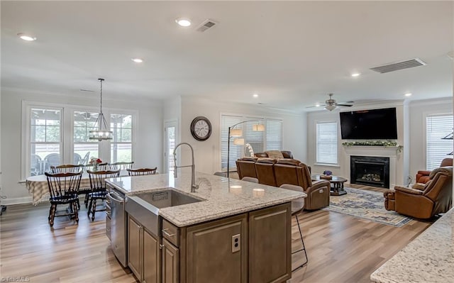 3609 Wesley Point Dr, Browns Summit, NC 27214 - kitchen with ornamental molding, dishwasher, a ceiling fan, a fireplace, and light wood-style floors