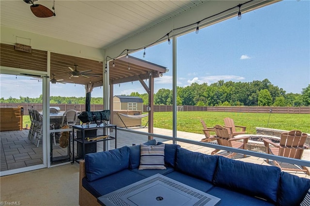 3609 Wesley Point Dr, Browns Summit, NC 27214 - fenced backyard with an outdoor living space with a fire pit, a ceiling fan, a storage unit, a patio area, and outdoor dining area