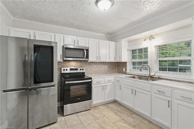 4624 Circle Dr, Winston-Salem, NC 27105 - kitchen featuring appliances with stainless steel finishes, white cabinetry, light countertops, decorative backsplash, and crown molding