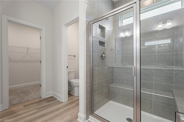 bathroom featuring hardwood / wood-style flooring, toilet, and an enclosed shower