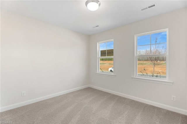 carpeted spare room featuring plenty of natural light