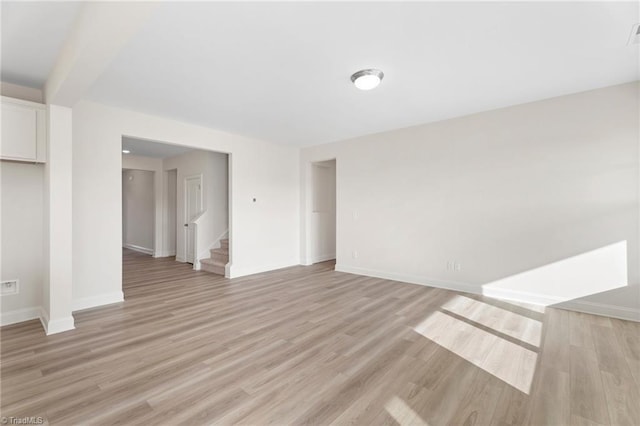 interior space featuring beamed ceiling and light hardwood / wood-style flooring