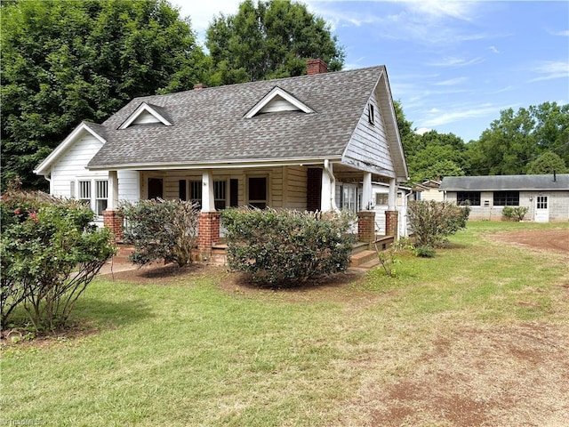 200 N 9th Ave, Mayodan, NC 27027 - view of front of house featuring a shingled roof, a porch, a chimney, and a front lawn