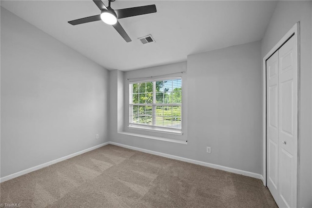 unfurnished bedroom featuring carpet floors, baseboards, a closet, and ceiling fan